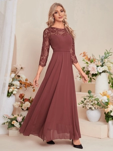 Close-up detail of burgundy lace bodice and flowing chiffon skirt of elegant evening gown
