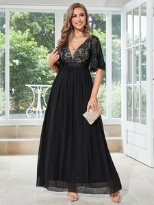 Dettaglio di ricamo in pizzo nero e tessuto chiffon su un elegante abito da sera nero
