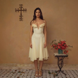 Elegant ivory midi dress with 3D floral appliques and ruffled hem in vintage interior