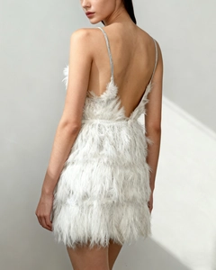 Detailed back view of white feather mini dress with deep open back and silver straps