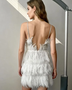 Detailed back view of a white mini dress with sequins and elegant feather trim