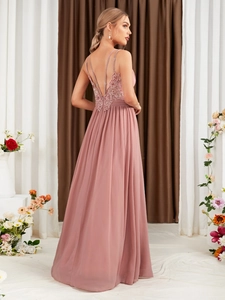Detail of elegant backless V-neck evening gown with lace embroidery and chiffon pleats