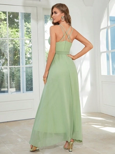 Detail of sage green backless maxi dress with thin crisscross straps and flowing skirt