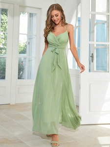 Detail view of a light green chiffon evening dress with spaghetti straps and a waist bow