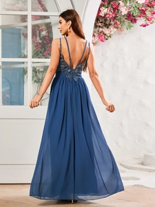 Detail of navy blue lace open back evening dress with floral embroidery and pleats
