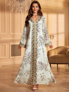 Detail view of the floral embroidery and gold sequins on the V-neck kaftan dress
