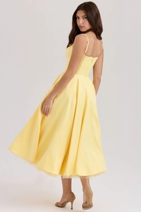 Vue latérale de la robe en satin jaune avec bustier corset et détails en tulle