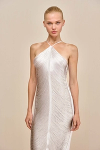 Detailed close-up of a luxury white and gold halter dress with elegant fringe texture
