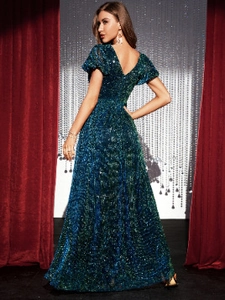 Dettaglio delle paillettes verde scuro e dello scollo a V di questo abito da sera