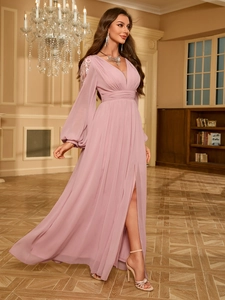 Détail d'une robe de soirée rose poudré avec col en V et broderies florales sur les épaules