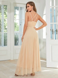 Close-up detail of champagne split evening gown featuring cross strap open back design