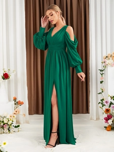Detail eines smaragdgrünen Abendkleids mit Cut-out-Laternenärmeln und hohem Beinschlitz