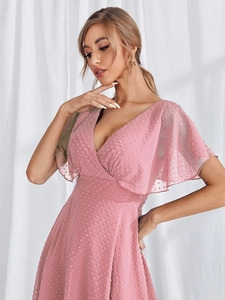 Detail of pink V-neck dress featuring Swiss dot fabric and elegant ruffled sleeves