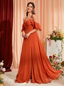 Detail of off-shoulder ruffled sleeves and pleated neckline on elegant brick red maxi dress