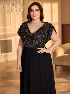 Detail of the elegant V-neck bodice with sparkling black and gold sequins on an evening gown