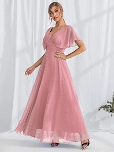 Detailed macro view of light pink Swiss dot fabric and V-neckline of this elegant dress
