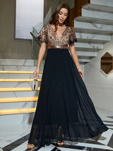 Détail de robe de soirée avec bustier à paillettes dorées et jupe fluide en mousseline noire