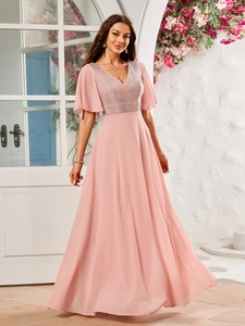 Detailed close-up of a pink V-neck evening gown with sparkling sequins and sheer flared sleeves