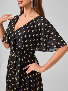 Dettaglio vestito nero con scollo a V, pois dorati e eleganti maniche con volant
