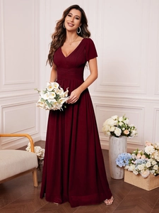 Close-up of the elegant V-neckline and intricate pleated details on the burgundy evening gown