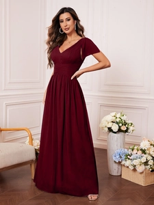 Detail showing deep red V-neck evening gown with pleated bodice and split bell sleeves