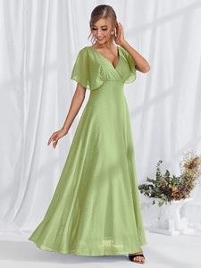 Close-up of Swiss dot fabric texture on an elegant light green V-neck evening gown