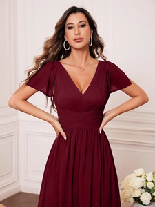 Detail of V-neck bodice with elegant pleats and flutter sleeves on wine red evening gown