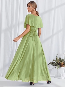 Detail of light green polka dot dress featuring a large bow tie on the open back