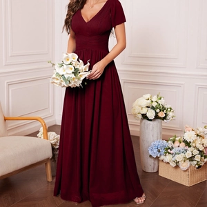 Detail view of the V-neckline and elegant pleated bodice on a burgundy evening gown