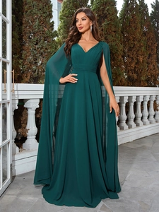 Detail of elegant dark green evening gown with deep V-neck and flowing cape sleeves