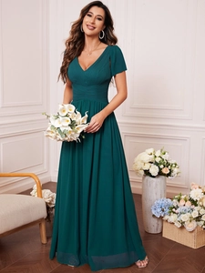 Detail of V-neck dark green evening dress featuring pleated bodice and flutter sleeves