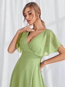 Close-up of light green chiffon fabric featuring elegant dotted swiss texture and ruffles