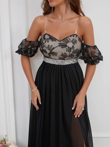 Detail of sequin embroidery bodice, puff sleeves, and high slit on a black chiffon gown