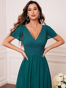 Detail of dark green V-neck evening gown with pleated waist and elegant butterfly sleeves