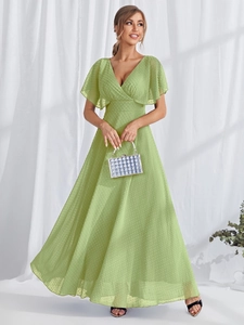 Close-up of green Swiss dot fabric dress with deep V-neck and ruffle sleeves