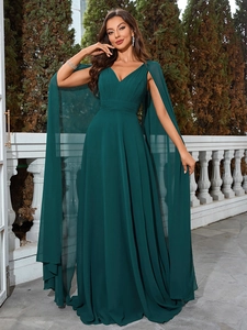 Detail of deep green V-neck evening gown featuring elegant cape sleeves and pleated waist