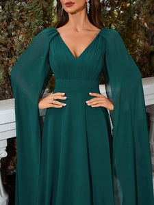 Detail of dark green V-neck evening gown featuring elegant pleated texture and cape sleeves