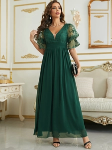 Close-up of deep green evening dress featuring delicate lace sleeves and deep V-neckline