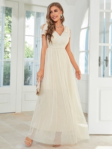 Detail of elegant cream maxi dress featuring delicate lace V-neck and polka dot mesh skirt