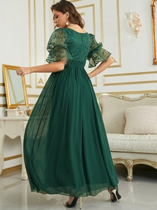 Detail of dark green lace bodice and sheer puffed sleeves on an elegant evening gown