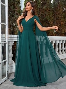 Detail of elegant dark green evening dress with a deep V-neck and flowing cape sleeves