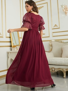 Close-up of elegant burgundy lace embroidery and ruffle sleeves on evening dress