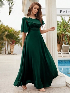 Elegante abito da sera in raso verde smeraldo con balze asimmetriche e spilla dorata