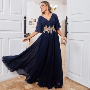 Détail d'une robe de soirée en mousseline marine avec broderie florale dorée à la taille