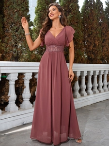 Détail d'une robe de soirée rose à col en V avec dentelle élégante à la taille et mousseline