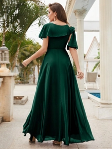 Elegante abito da sera verde smeraldo con maniche a mantella a balze e silhouette fluida