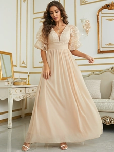 Detail of elegant champagne evening dress with lace bodice and layered puff sleeves