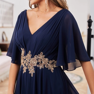 Détail de la robe de soirée bleu marine élégante avec broderie florale dorée à la taille