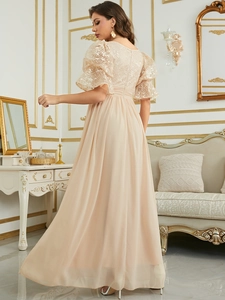 Detailed view of apricot evening dress featuring exquisite lace floral patterns and mesh sleeves