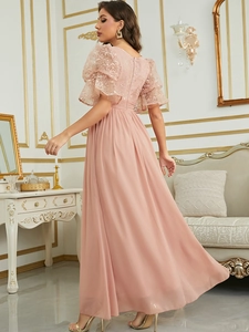 Close-up of elegant lace embroidery and puff sleeves on a dusty pink evening gown